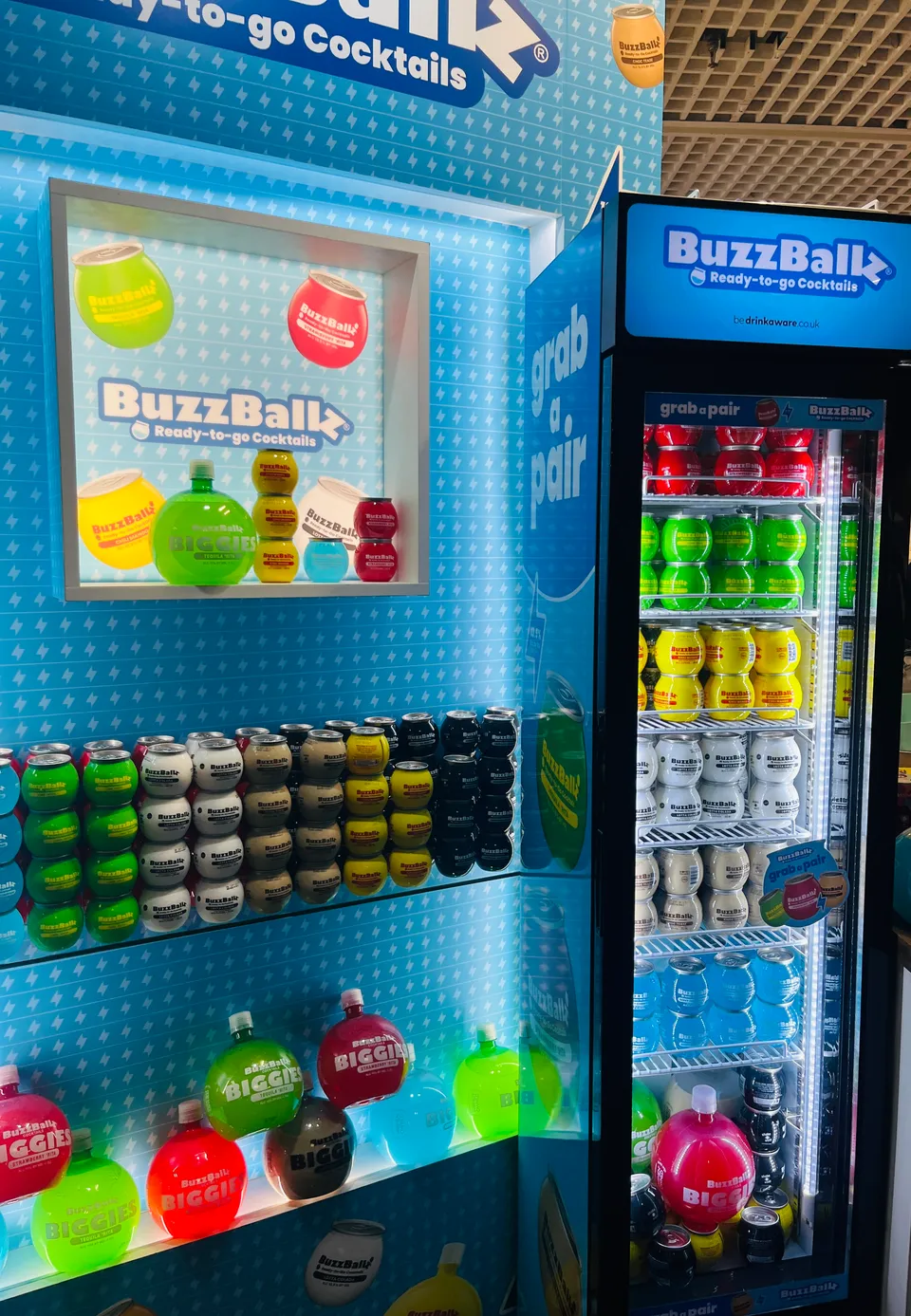 BuzzBallz showcases its ready-to-drink cocktails through a colourful display and branded fridge at TFWA Cannes 2026.